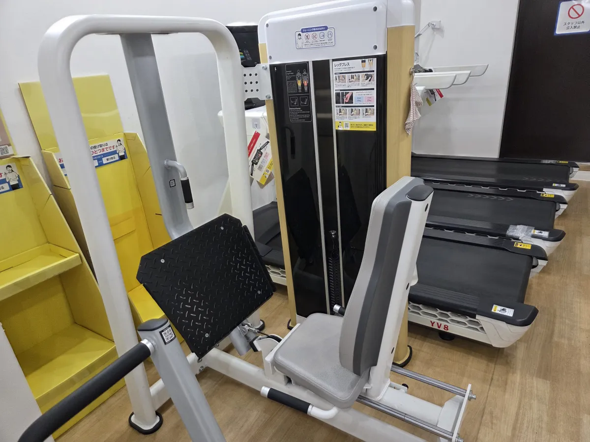 chocoZAPのレッグプレス。白いフレームにグレーの座席と背もたれがあり、足を置く黒い板が動くタイプ