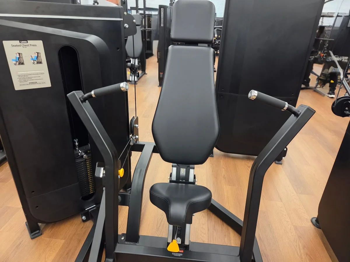 FIT PLACE24のチェストプレス（LEXCO製）の正面。黒いフレームに背もたれとシートがあり、左右にグリップが付いている